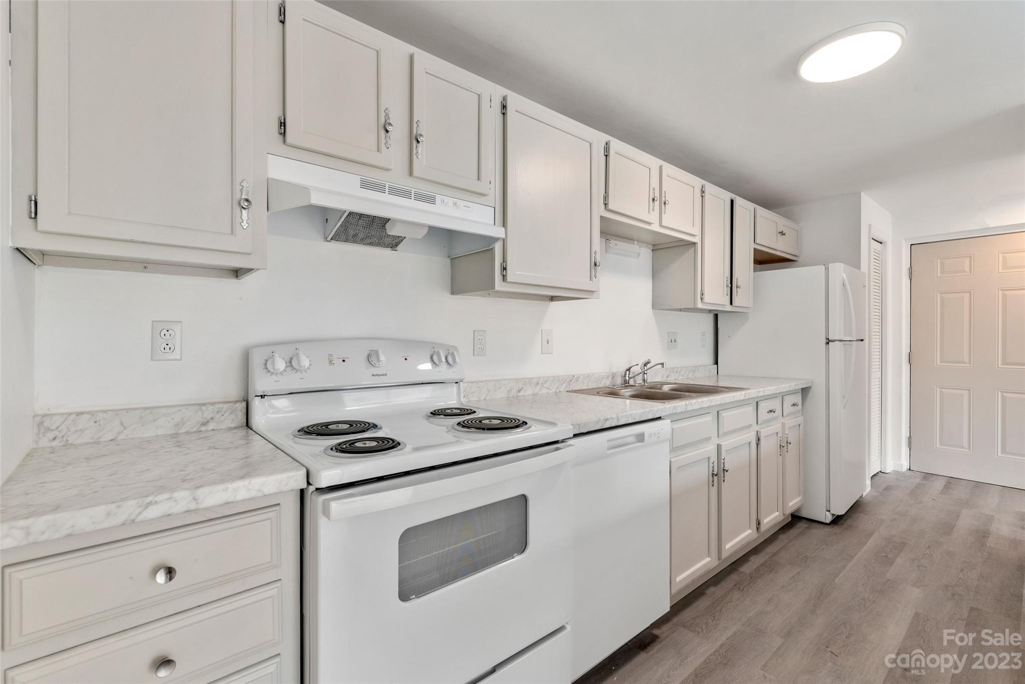 9333 Old Concord Road, Unit J Charlotte, NC 28213 - Photo 9 of 17 a kitchen with granite countertop white cabinets and white appliances