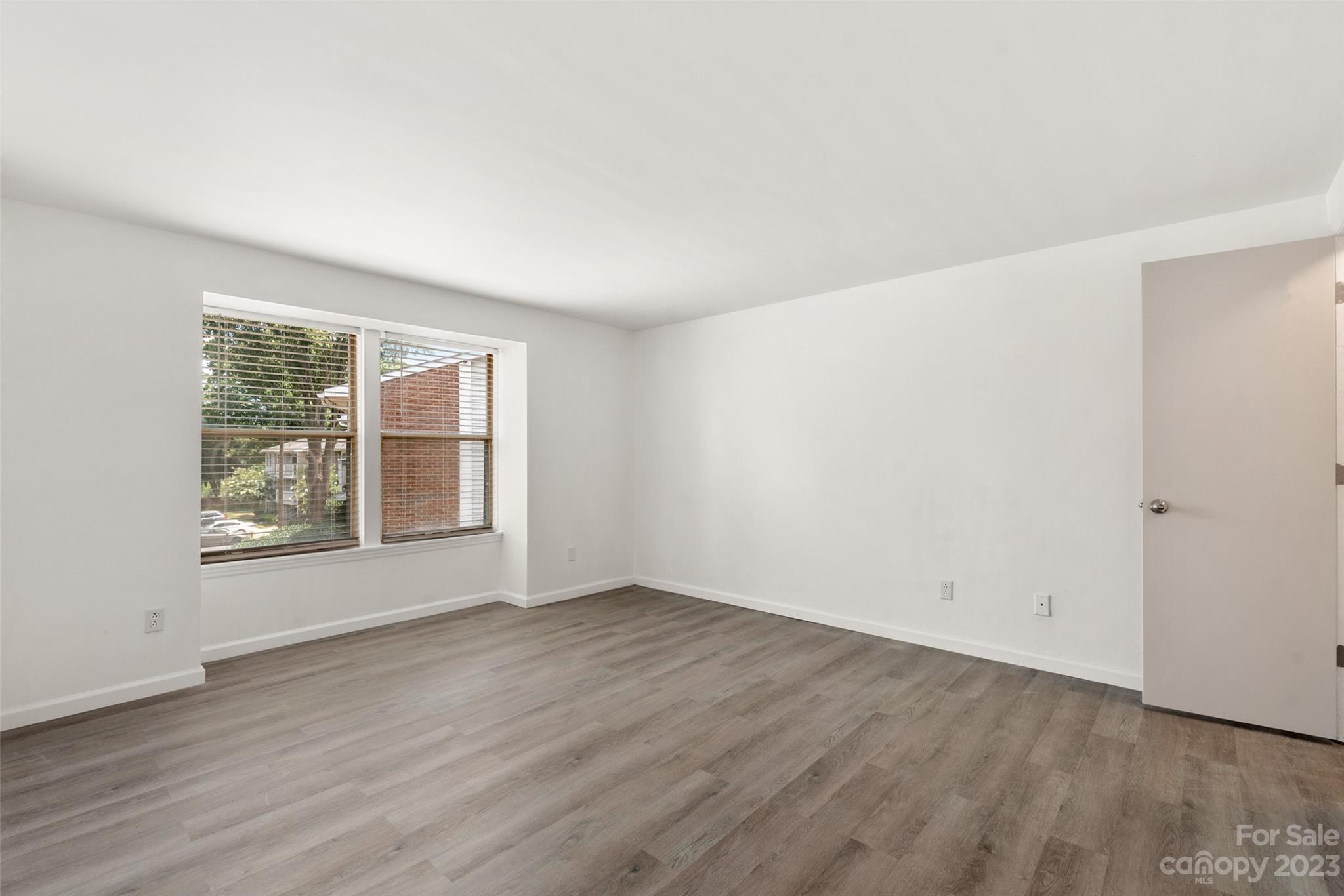 9333 Old Concord Road, Unit J Charlotte, NC 28213 - Photo 10 of 17 an empty room with wooden floor and windows