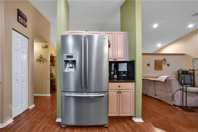 a kitchen with stainless steel appliances a refrigerator and wooden floor