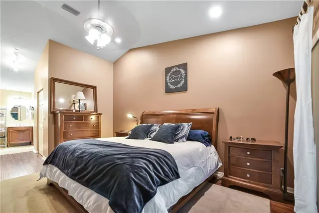 a bedroom with a large bed and a chandelier