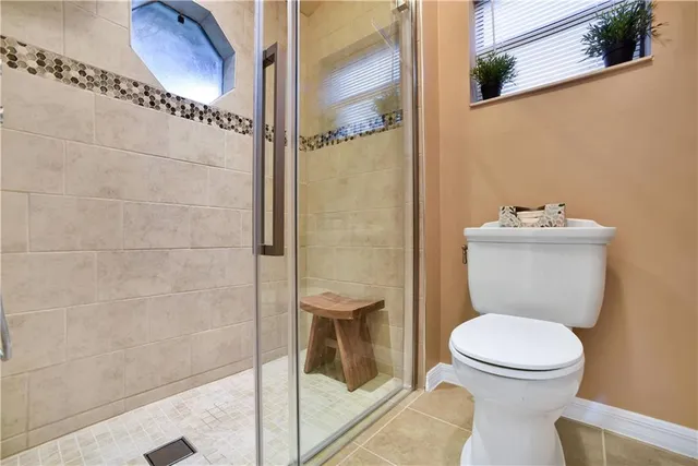 a bathroom with a toilet and a shower