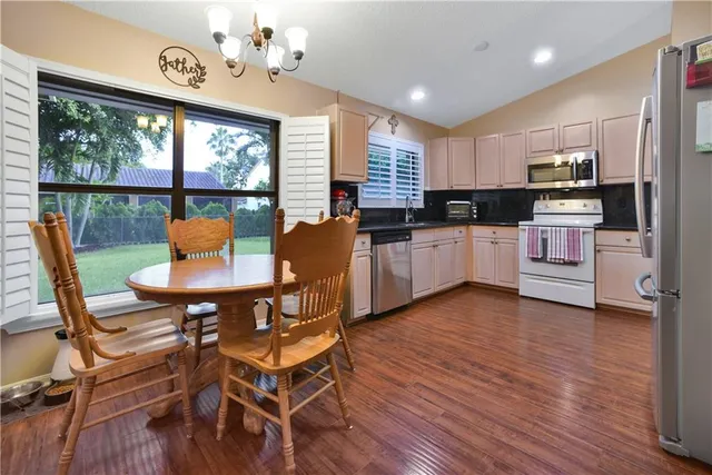 a kitchen with stainless steel appliances kitchen island wooden floors and white cabinets