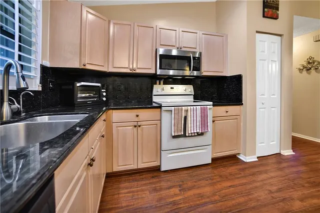 a kitchen with a sink stove and microwave