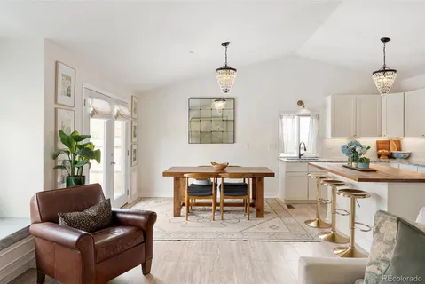 a living room with furniture a chandelier and a dining table
