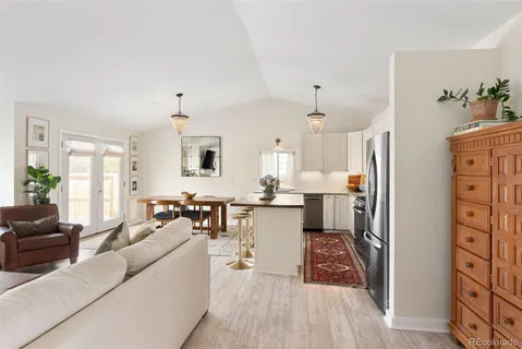 a living room with furniture a dining table and chairs with wooden floor