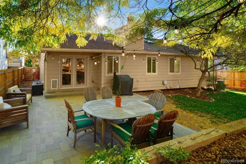 a backyard of a house with barbeque oven table and chairs