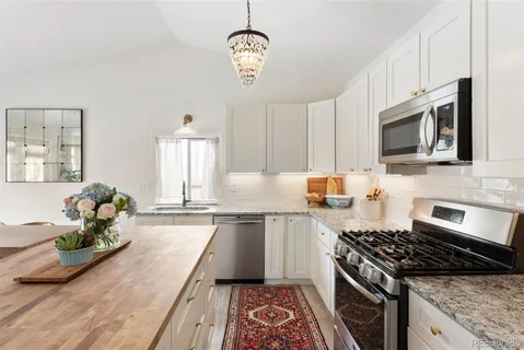 a kitchen with stainless steel appliances granite countertop a stove a sink dishwasher and microwave oven with cabinets