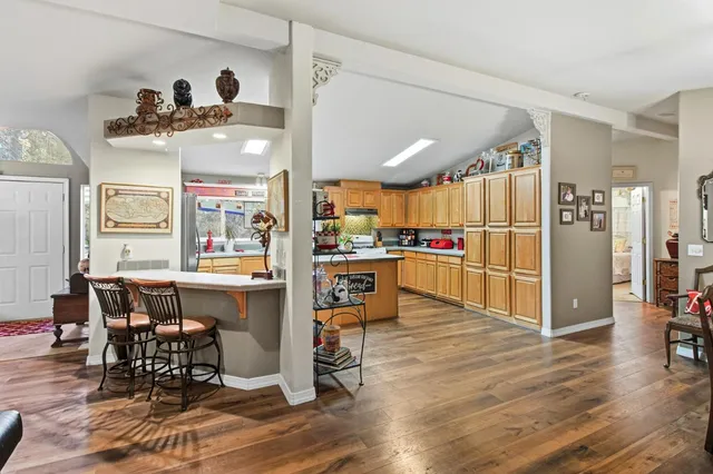 a kitchen that has a lot of cabinets in it and wooden floor