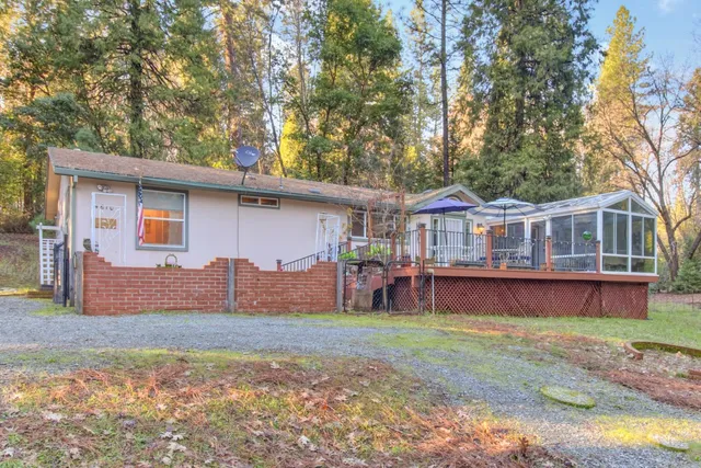 a view of a patio with table and chairs under an umbrella with wooden floor