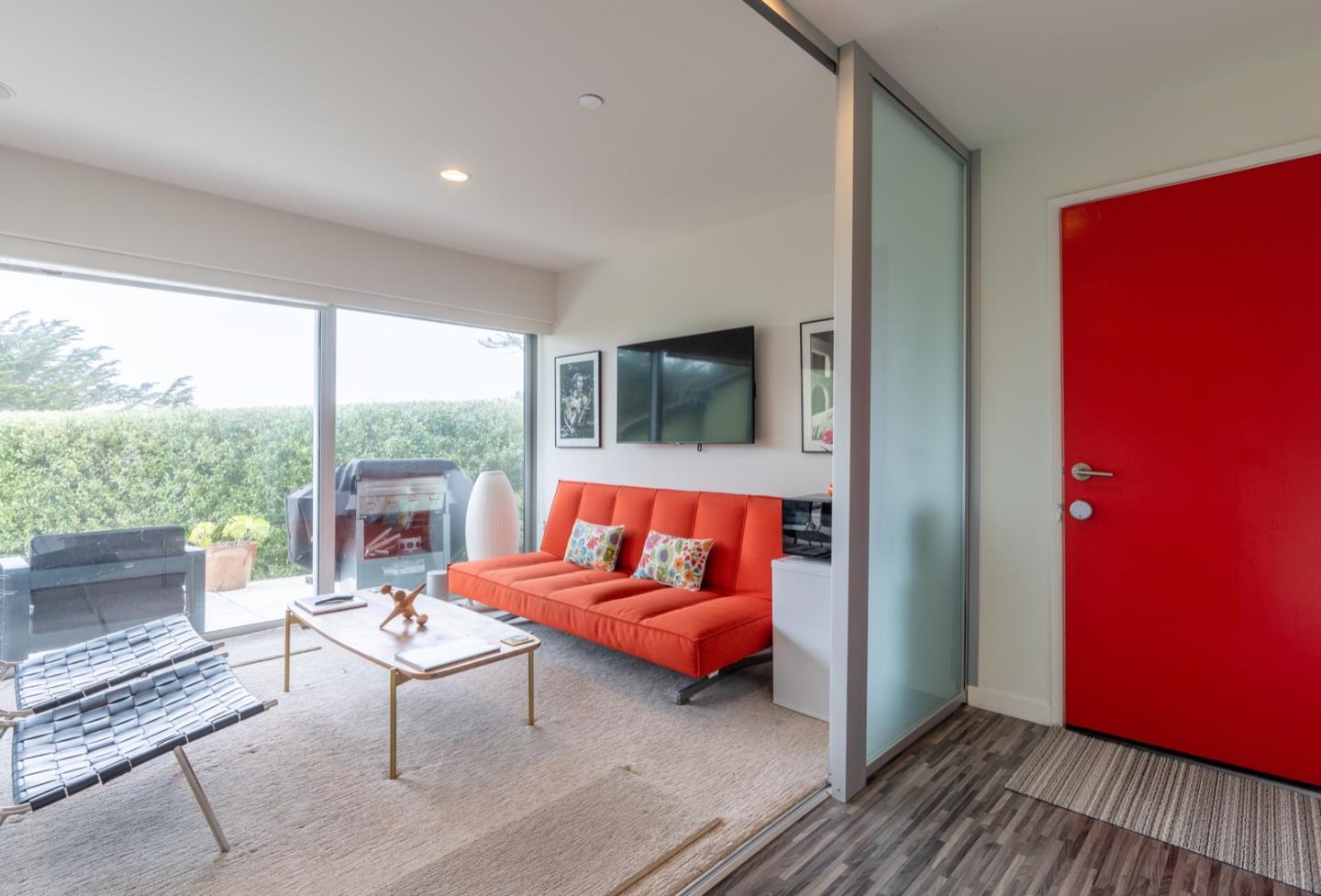 451 Talbot Avenue Pacifica, CA 94044 - Photo 20 of 38 a living room with furniture a flat screen tv and a floor to ceiling window
