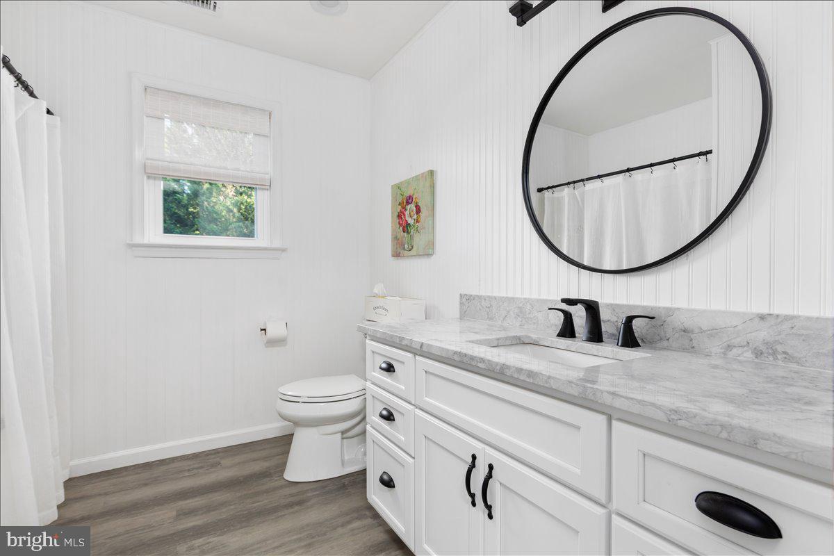 129 Old Wagon Road Winchester, VA 22602 - Photo 24 of 59 a bathroom with a granite countertop toilet a sink and a mirror