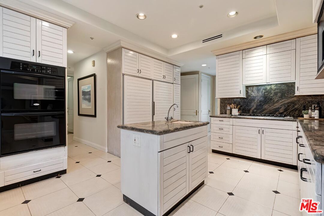 110 North Oakhurst Drive Beverly Hills, CA 90210 - Photo 12 of 29 a kitchen with stainless steel appliances kitchen island granite countertop a sink and cabinets