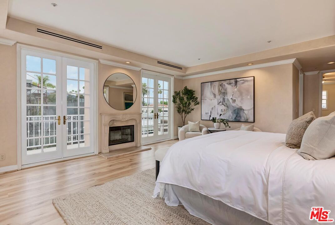 110 North Oakhurst Drive Beverly Hills, CA 90210 - Photo 14 of 29 a bedroom with a large bed and a fireplace