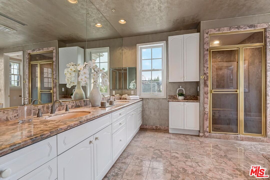 110 North Oakhurst Drive Beverly Hills, CA 90210 - Photo 16 of 29 a large bathroom with kitchen island granite countertop a sink and white cabinets