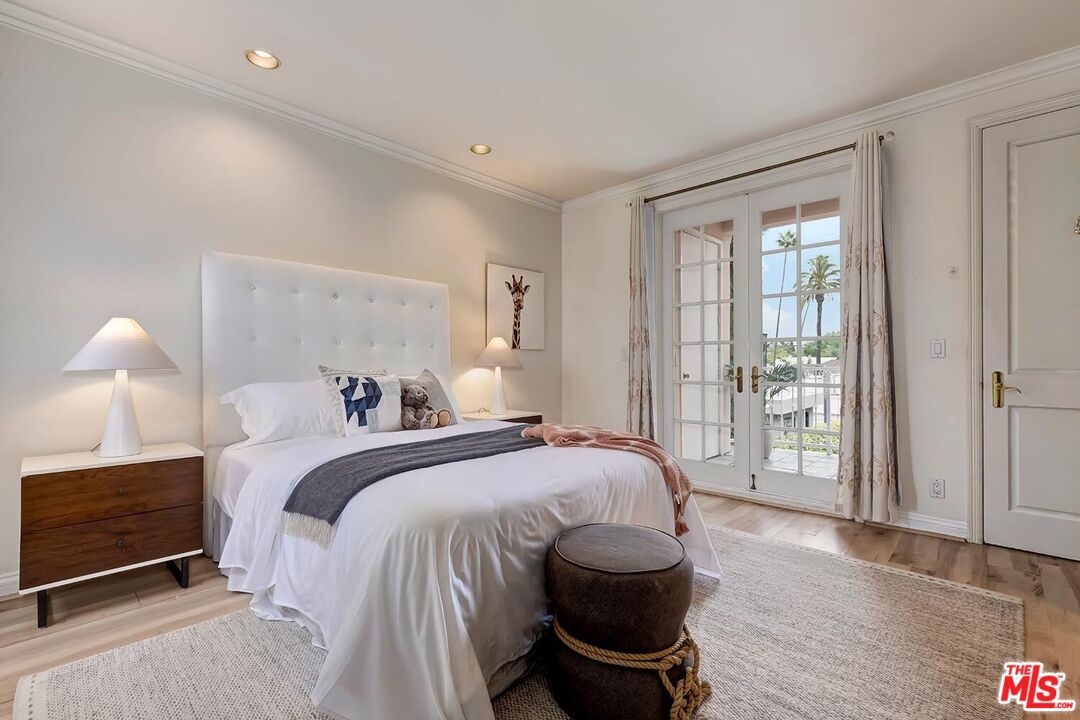 110 North Oakhurst Drive Beverly Hills, CA 90210 - Photo 20 of 29 a spacious bedroom with a bed and wooden floor