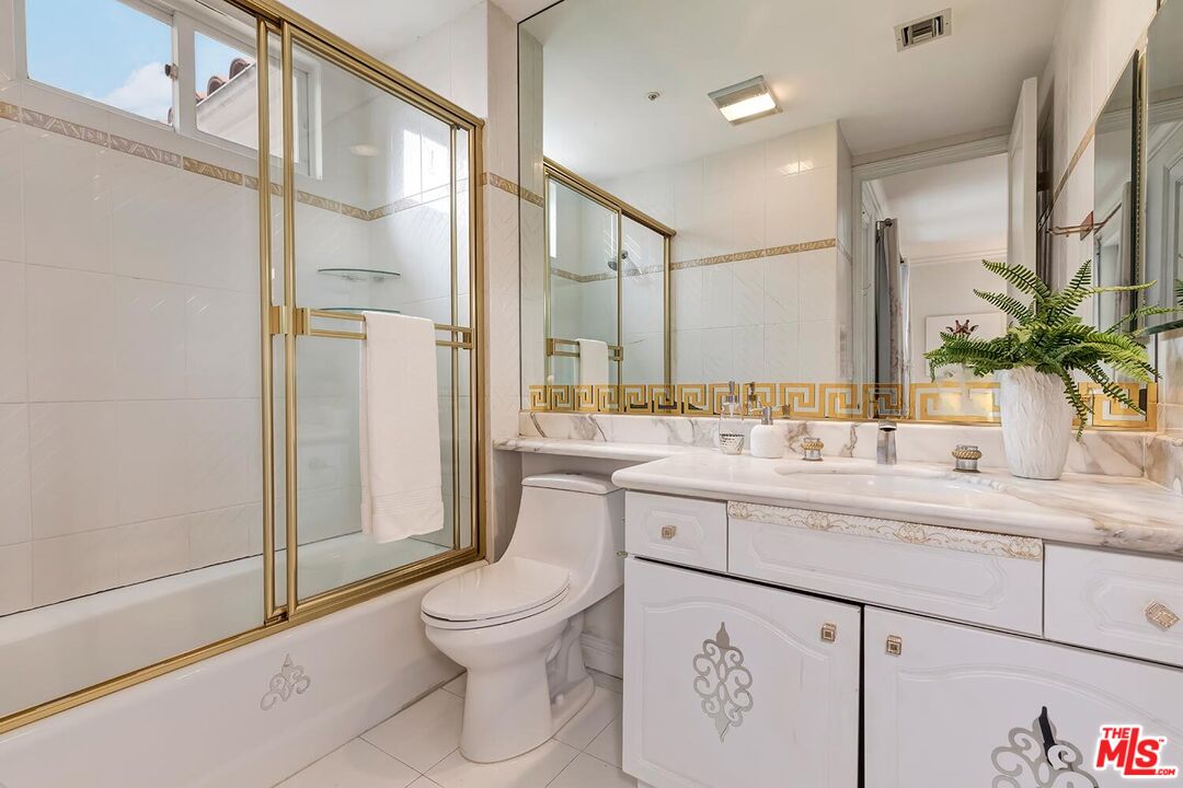 110 North Oakhurst Drive Beverly Hills, CA 90210 - Photo 21 of 29 a bathroom with a granite countertop sink mirror vanity and toilet