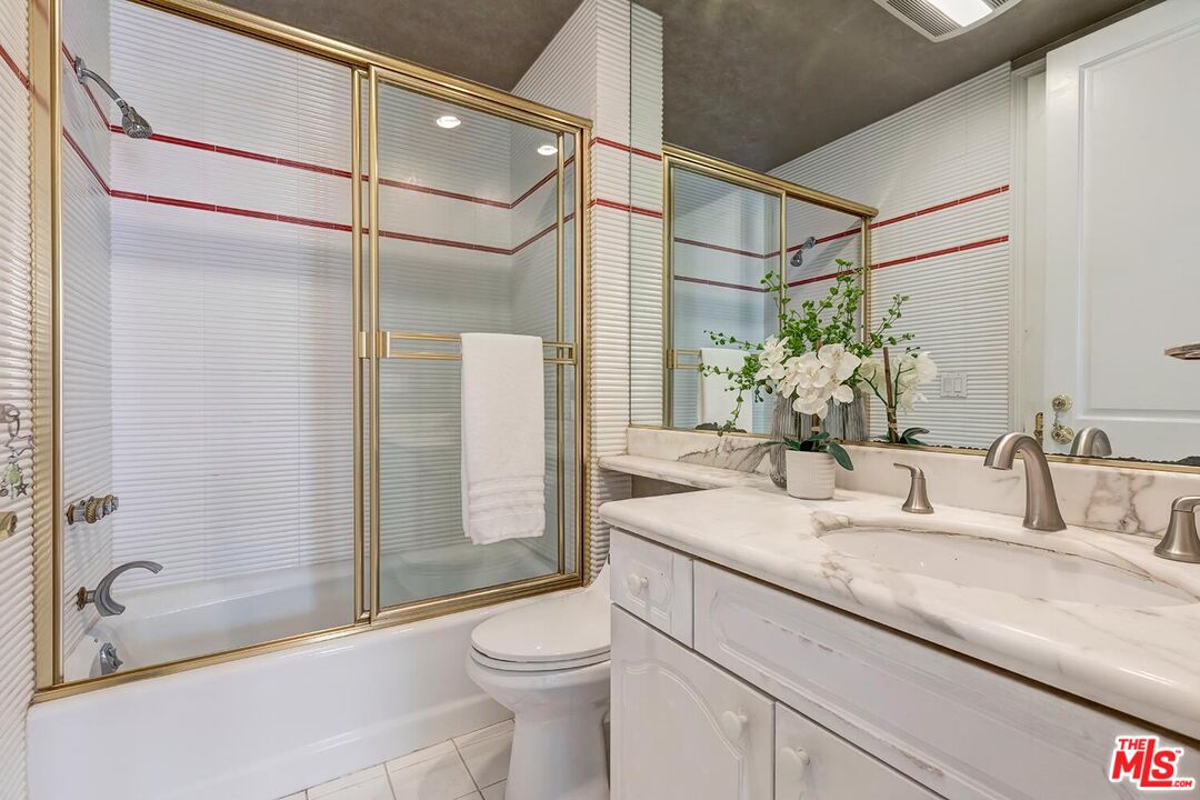 110 North Oakhurst Drive Beverly Hills, CA 90210 - Photo 24 of 29 a bathroom with a granite countertop sink a toilet and shower