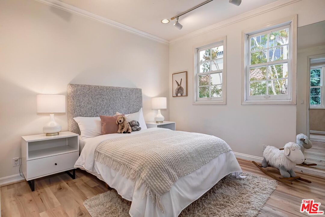 110 North Oakhurst Drive Beverly Hills, CA 90210 - Photo 25 of 29 a bedroom with a bed and wooden floor