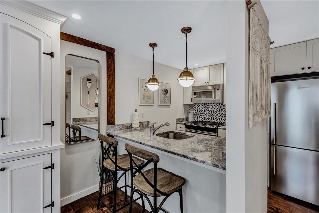 21 Milestone Way, Unit 620 Mashpee, MA 02649 - Photo 11 of 28 a kitchen with a table and chairs in it