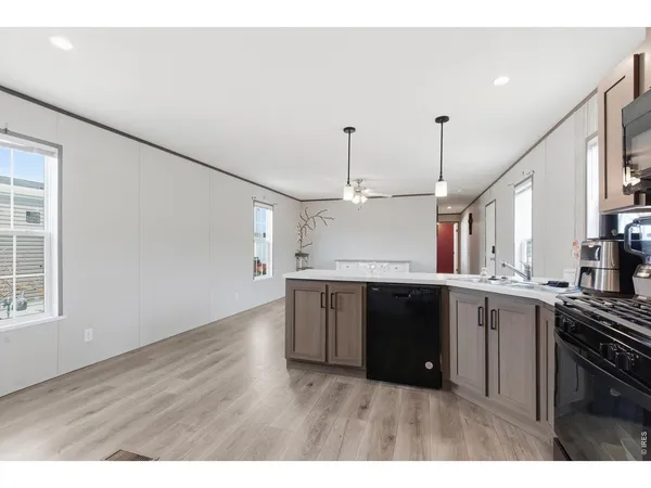 a kitchen with a sink dishwasher a stove and a wooden floor