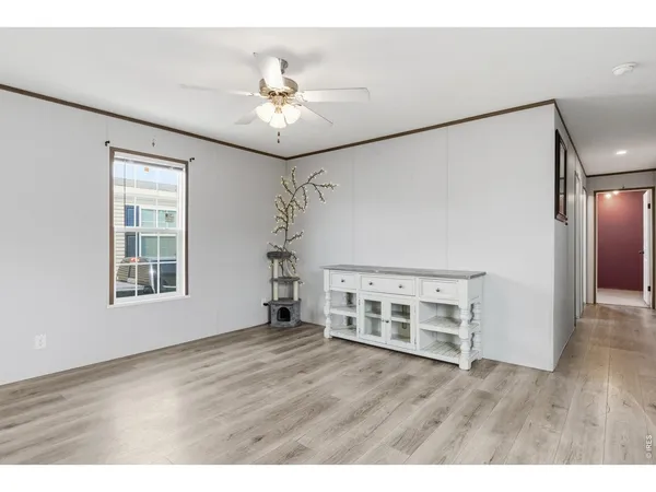 a view of an empty room with a window and wooden floor
