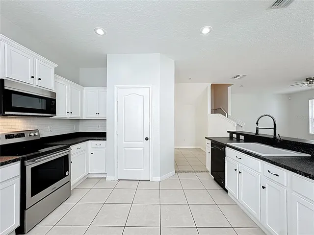 a kitchen with white cabinets and stainless steel appliances