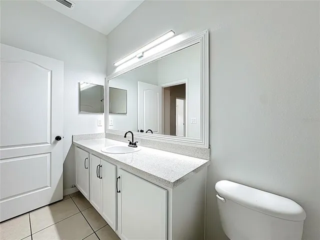 an empty room with chandelier fan