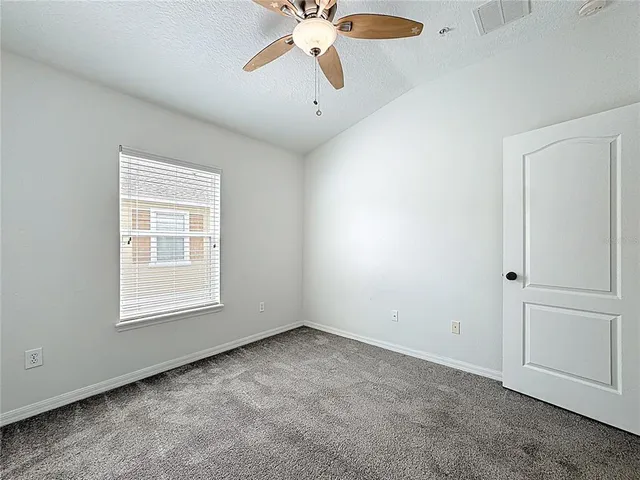 an empty room with chandelier fan