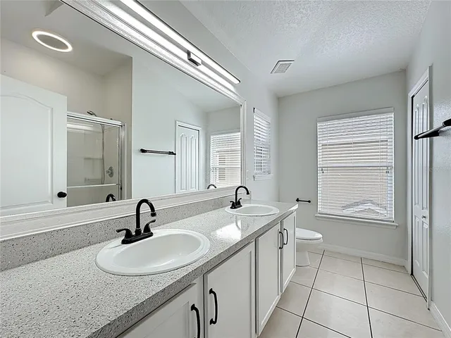 a bathroom with a toilet a sink a mirror and window