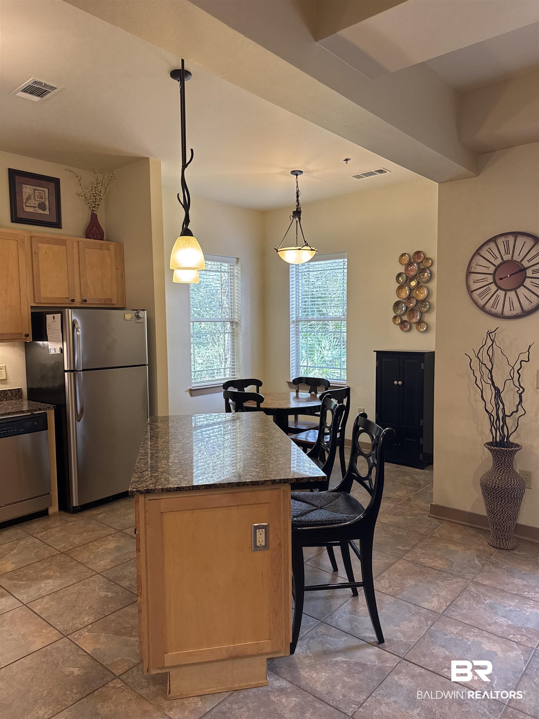 1430 Regency Road, Unit C101 Gulf Shores, AL 36542 - Photo 7 of 32 Kitchen with stainless steel appliances, decorative light fixtures, dark stone counters, a kitchen island, and light wood finish cabinetry