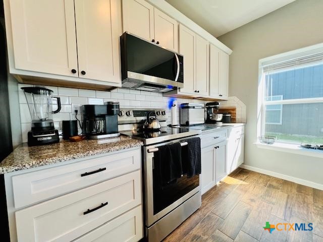 2824 Harrison Avenue Port O'Connor, TX 77982 - Photo 11 of 48 a kitchen with stainless steel appliances granite countertop a sink a stove and a microwave