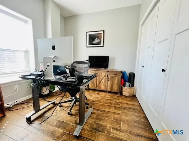 a view of a workspace with furniture and a window