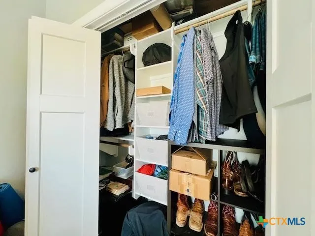 a view of walk in closet with clothes and shoes