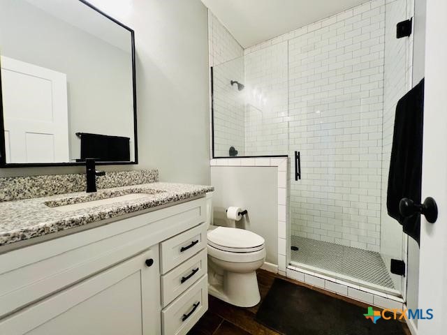 2824 Harrison Avenue Port O'Connor, TX 77982 - Photo 24 of 48 a bathroom with a granite countertop sink a toilet a mirror and shower