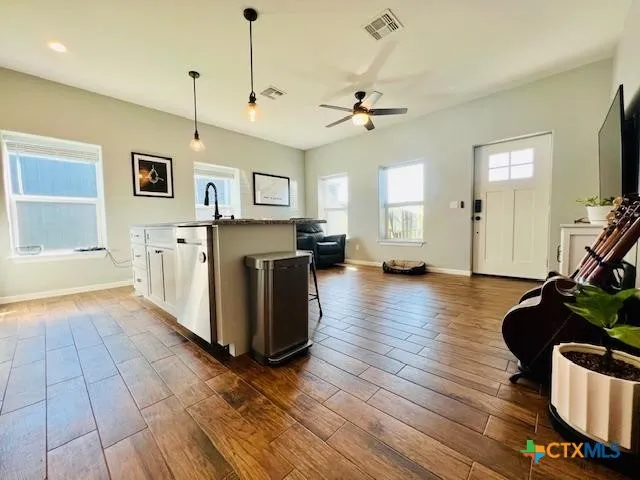 a living room with furniture and a wooden floor