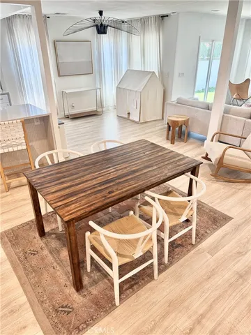 a living room with a couch a rug kitchen view and a large window