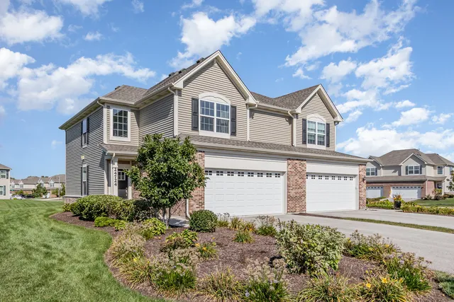 a front view of a house with a yard and garage