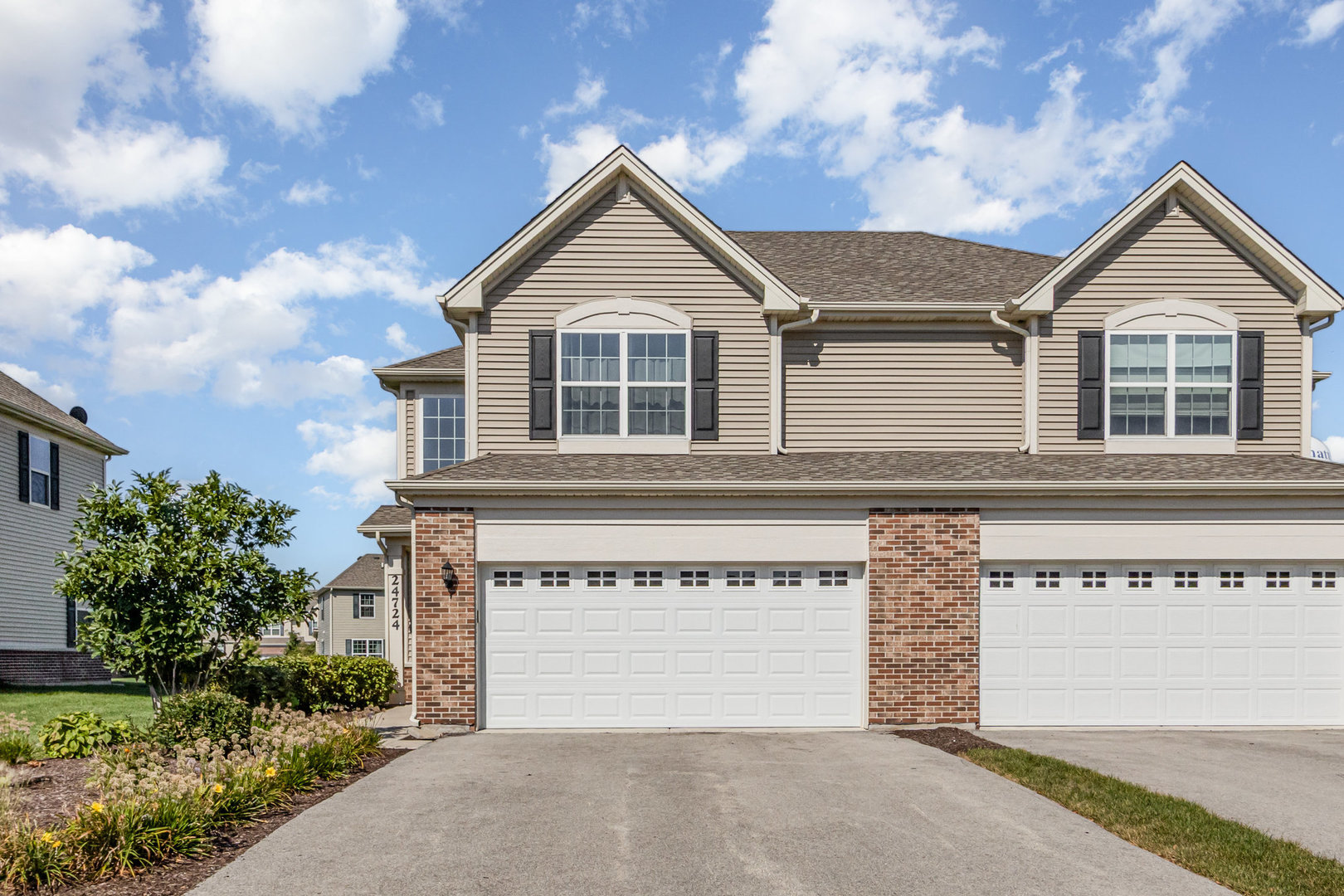 24724 McCormick Way Manhattan, IL 60442 - Photo 2 of 24 a front view of a house with a yard and garage