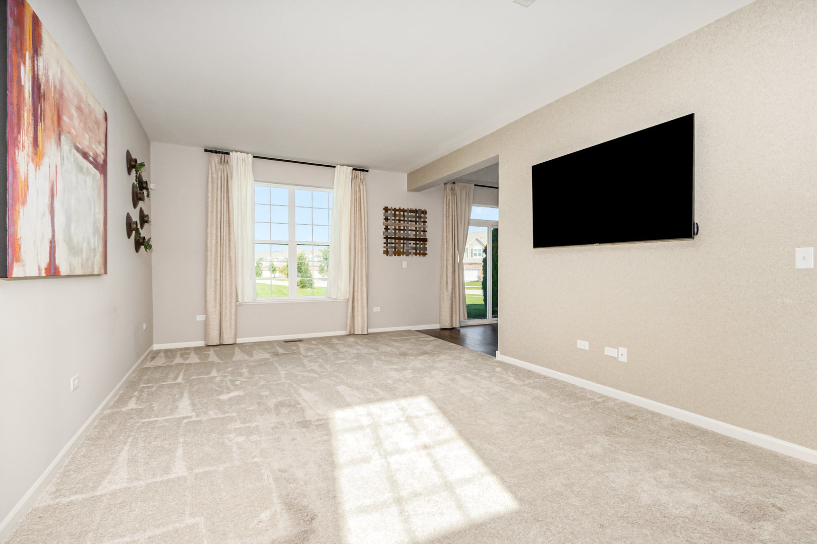 24724 McCormick Way Manhattan, IL 60442 - Photo 5 of 24 a view of an empty room with a window and a flat screen tv