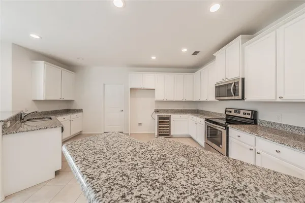 a kitchen with granite countertop a stove top oven sink and cabinets