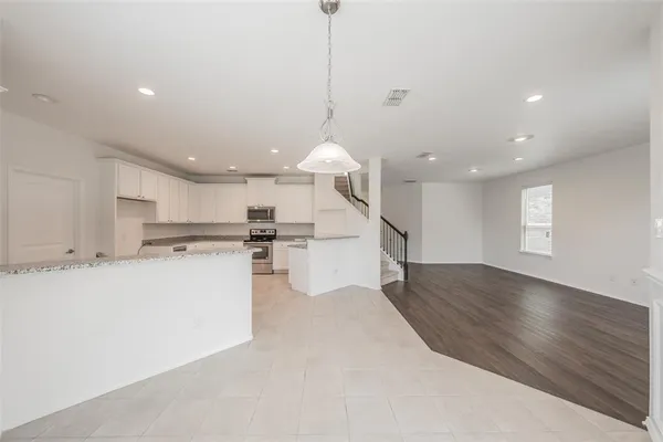 a open kitchen with white cabinets and white appliances