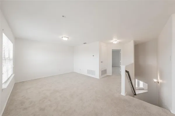 an empty room with a fireplace and windows
