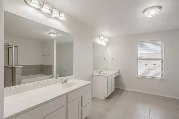 a bathroom with a sink a large mirror and shower