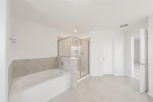 a spacious bathroom with a bathtub and shower