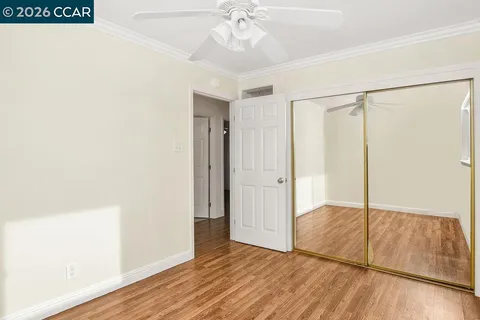 an empty room with wooden floor and cabinet