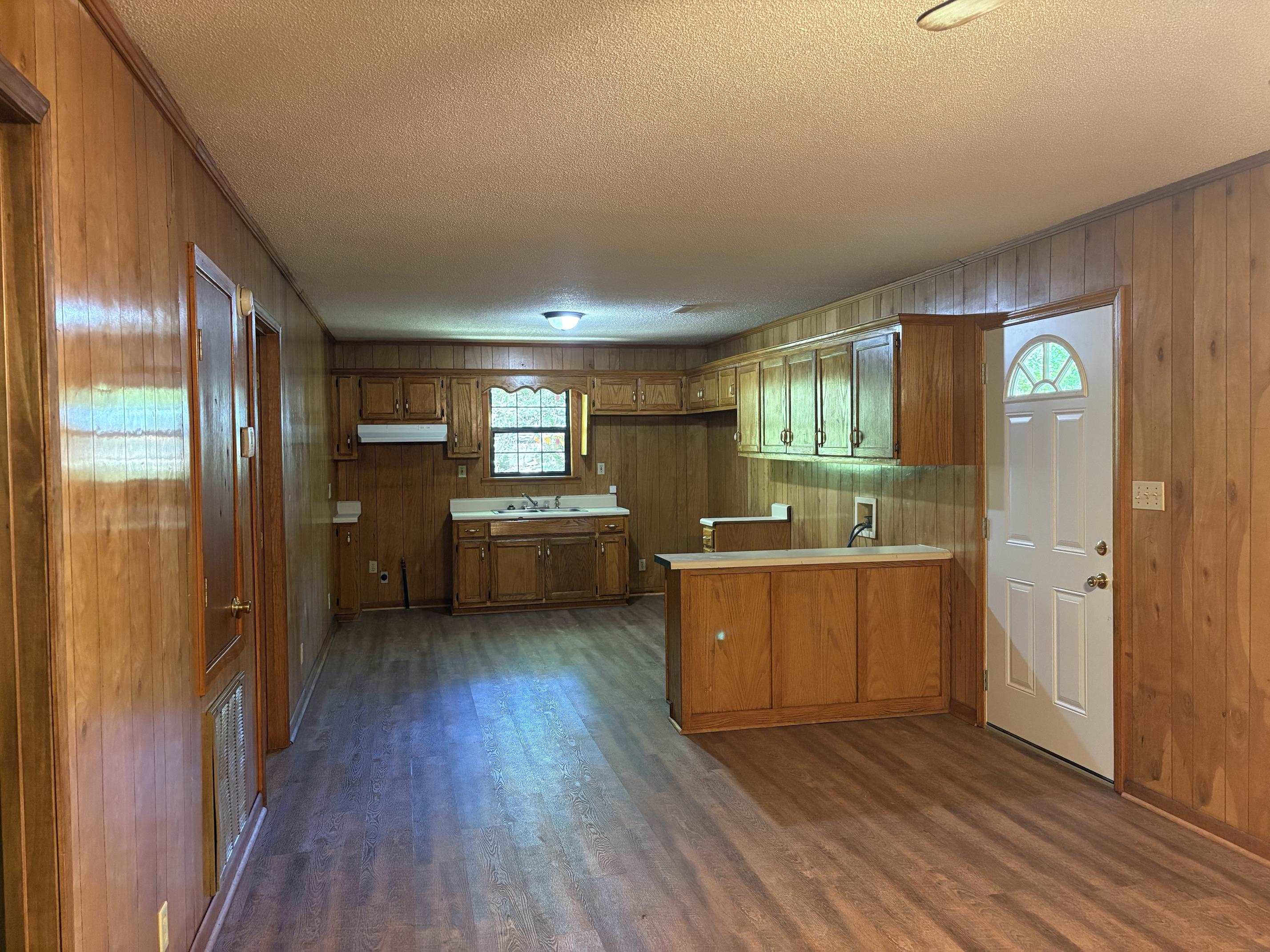 146 Walker Street Ripley, TN 38063 - Photo 5 of 14 a kitchen with cabinets wooden floor and stainless steel appliances