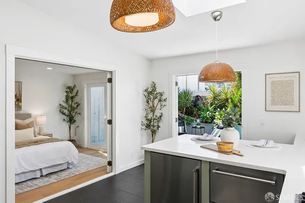 a spacious bedroom with a bed and a potted plant