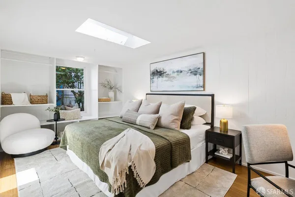 a bedroom with a bed and a painting on the wall