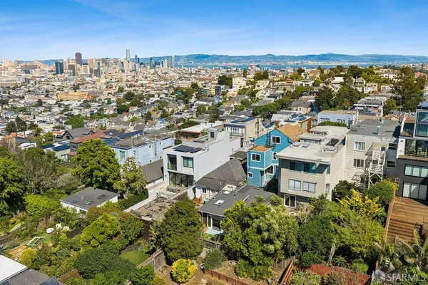 an aerial view of residential houses with city view