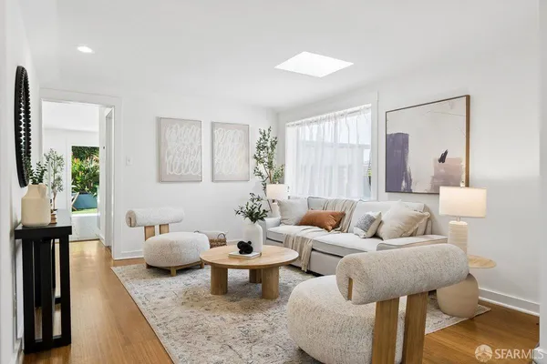 a living room with furniture and wooden floor